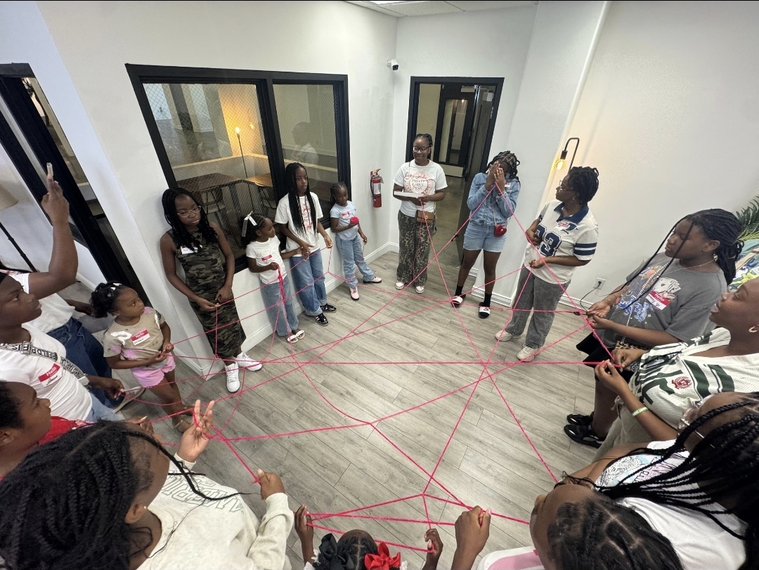 Girls connected in a sisterhood string activity